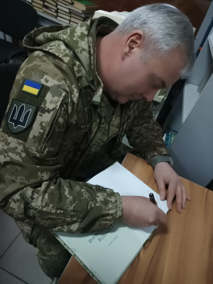 Генерал Наєв підписує книгу авторства його помічника «Стратегія протистояння» про перші дні війни