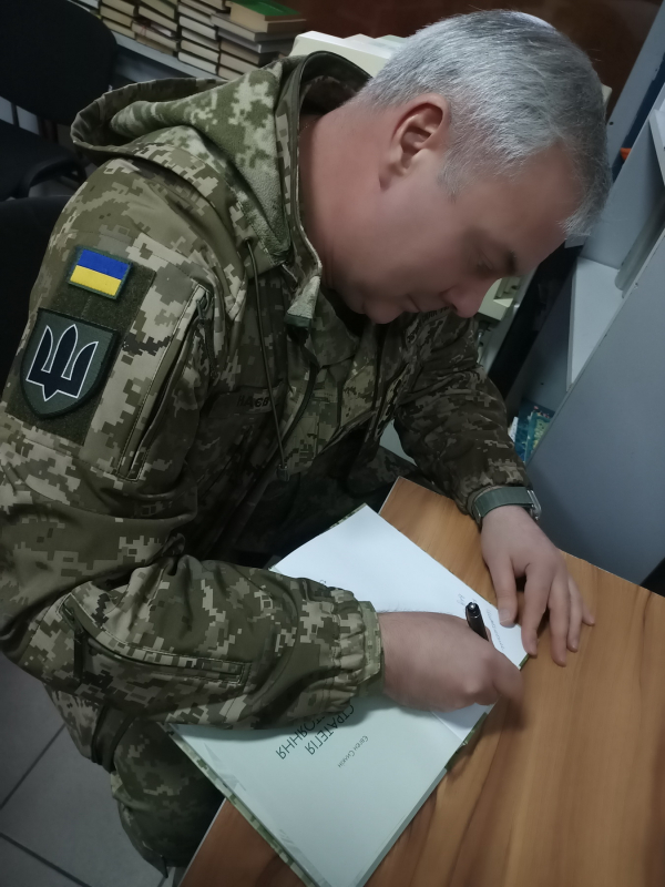 Генерал Наєв підписує книгу авторства його помічника «Стратегія протистояння» про перші дні війни
