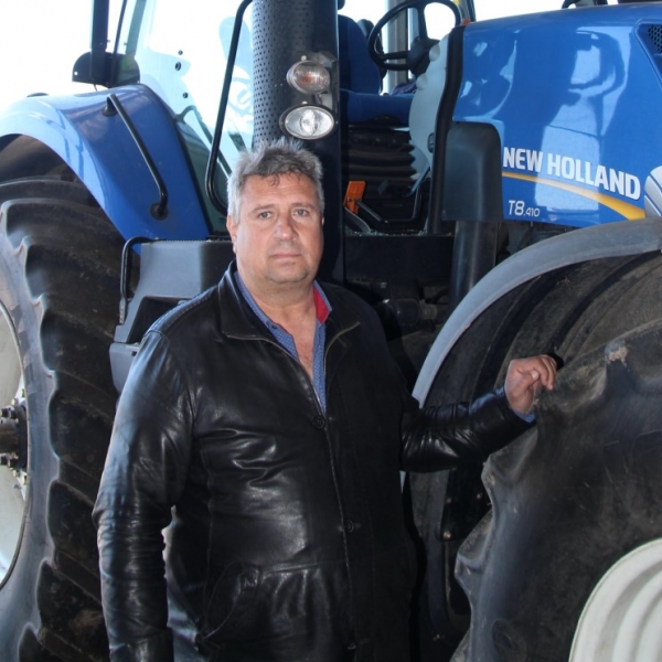 Григорій Ткаченко біля новенького трактора, який уцілів