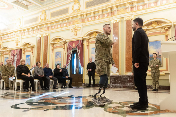 Володимир Зеленський вручає Андрієві Сергієнку сертифікат на житло